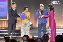 La vice-présidente de la République, Vo Thi Anh Xuân, et le secrétaire du Comité municipal du Parti de Da Nang, Lê Ngoc Quang, remettent le Grand Prix de la compétition asiatique aux représentants du film indien Full Plate, sacré meilleur film de cette quatrième édition. Photo: VNA