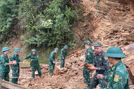 Des officiers et soldats du poste-frontière de Chieng On dégagent une route après un glissement de terrain. Photo : VNA