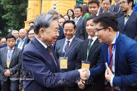Le secrétaire général du Parti et président Tô Lâm (gauche) et des représentants des Vietnamiens à l'étrangers. Photo: VNA