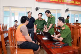 Le colonel Trần Quốc Huy, directeur adjoint de la Police de la province de Lao Cai, participe à l’interrogatoire du suspect impliqué dans le réseau. Photo: VNA