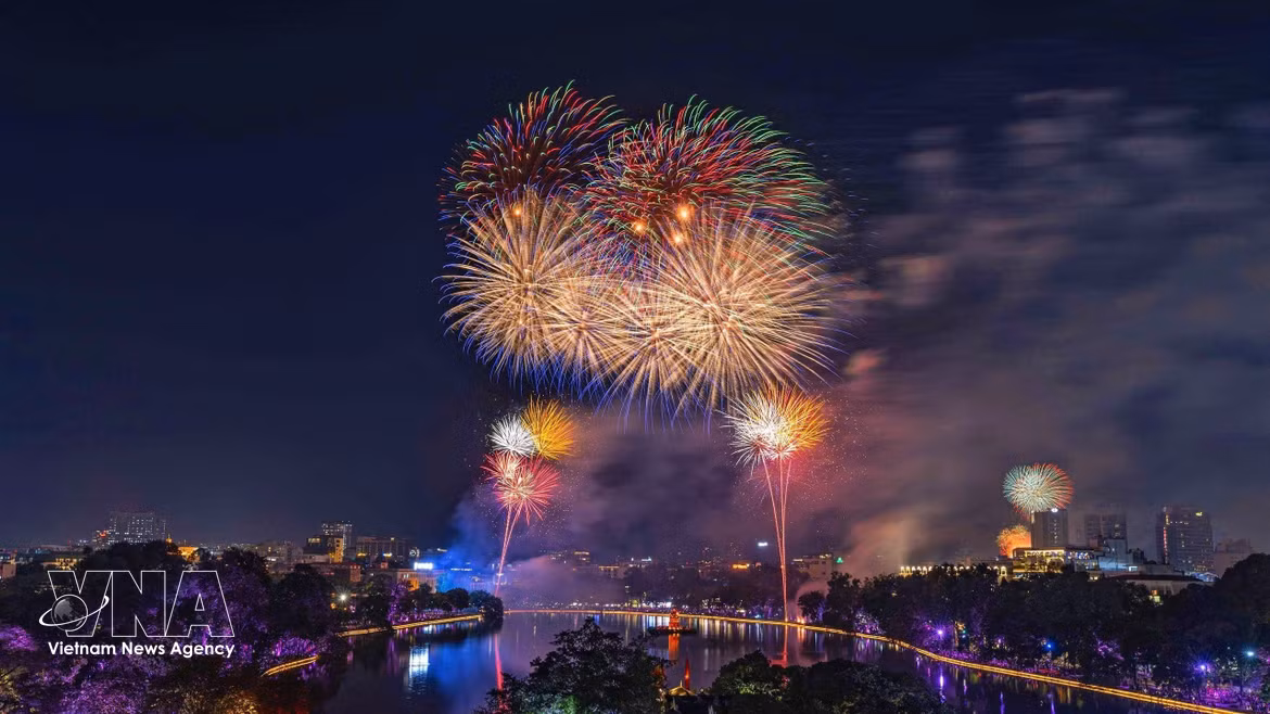 Un éblouissant spectacle de feux d’artifice illumine le ciel au-dessus du lac Hoan Kiem. Photo : VNA