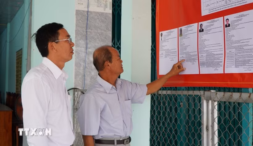 Des électeurs consultent les brèves biographies des candidats au Conseil populaire de la commune de Tan Hong, province de Dong Thap, mandat 2026-2031. Photo : VNA