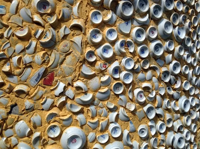 Partie d’un mur du sanctuaire principal couvert de bols, d’assiettes et de fragments de faïence.