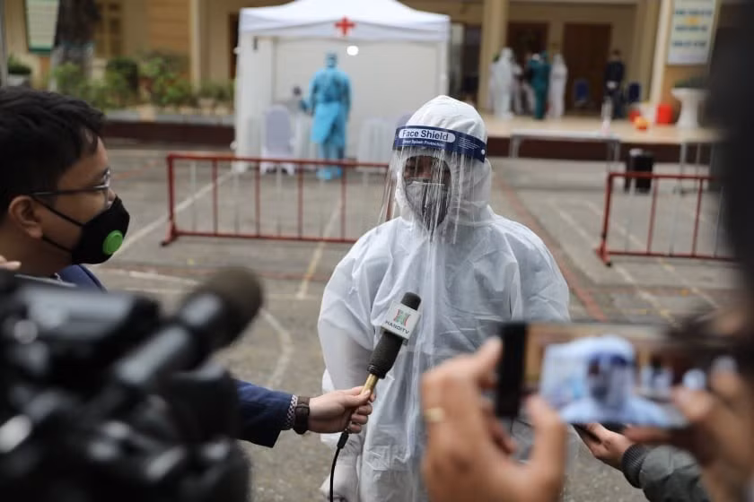 Un représentant du groupe de travail au poste de test rapide du COVID-19 au collège Dong Da (Hanoï) accorde une interview à la presse, dans la matinée du 31 mars 2020. Photo : Thanh Tung - VNA