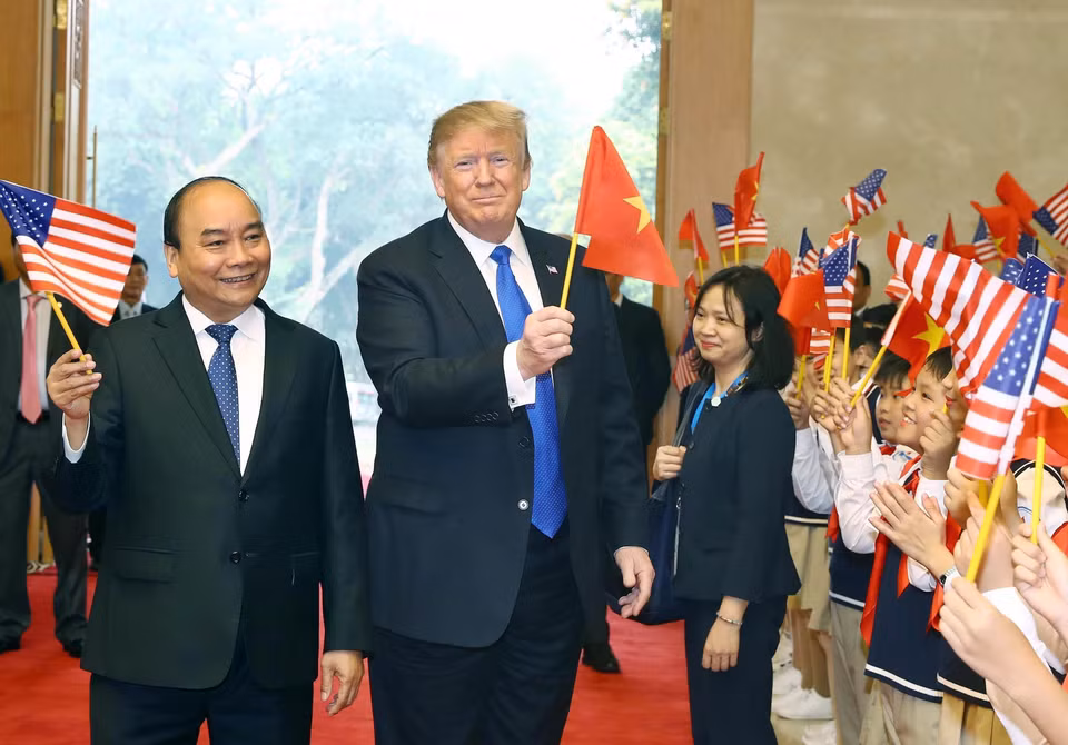 Le Premier ministre Nguyen Xuan Phuc (gauche) et le président américain Donald Trump ont agité les drapeaux des deux pays, lors d'une cérémonie d'accueil organisé le 27 février 2019 au siège du gouvernement vietnamien à l'intention du dirigeant américain. Photo : Thong Nhat – VNA. 