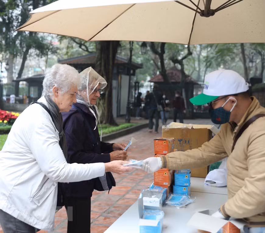 Des masques de protection distribuées gratuitement aux visiteurs, une fois arrivée au Temple de la Littérature. Photo: VietnamPlus 