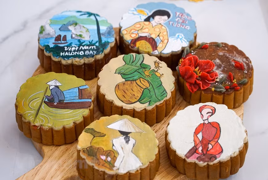 Des images caractéristiques de la culture vietnamienne comme l’ao dài, la baie de Ha Long, la fleur de lotus,... décorent ses gâteaux de lune. Il y a une partie émerveillement quand des enfants ou une personne découvrent ces pâtisseries. Photo: VietnamPlus