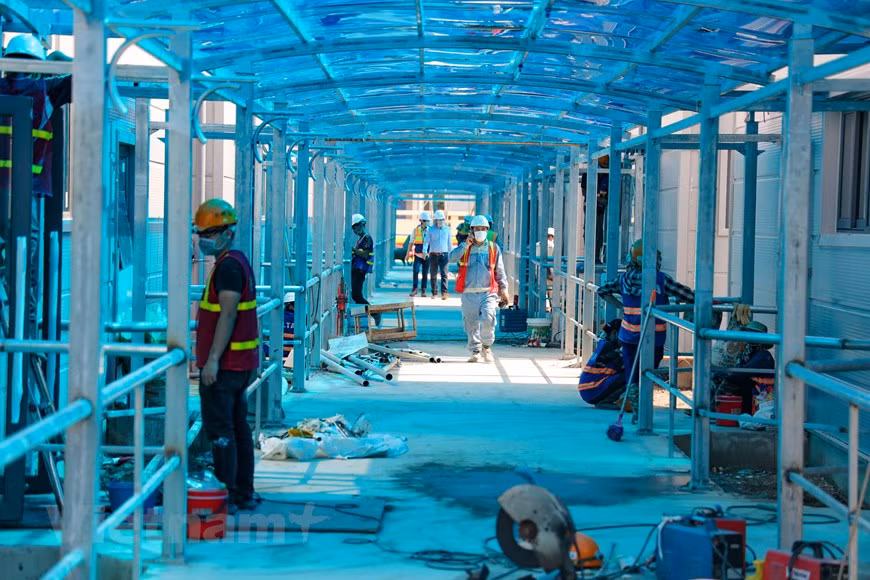 Les ingénieurs et ouvriers du groupe Delta travaillent d'arrache-pied pour achever la construction de cet ouvrage. Les machines vrombissent jour et nuit sur le chantier où sortira de terre l'un des établissements les plus modernes au Vietnam pour traiter les patients atteints de Covid-19. C’est un projet urgent au service de la prévention et du contrôle du coronavirus. Hanoi accorde une attention particulière à ce projet et facilite la construction pendant la période de distanciation sociale. Le directeur de cet hôpital de campagne est le professeur associé et docteur Nguyên Lân Hiêu, qui est également directeur de l'Hôpital universitaire de médecine de Hanoi. Photo: VietnamPlus
