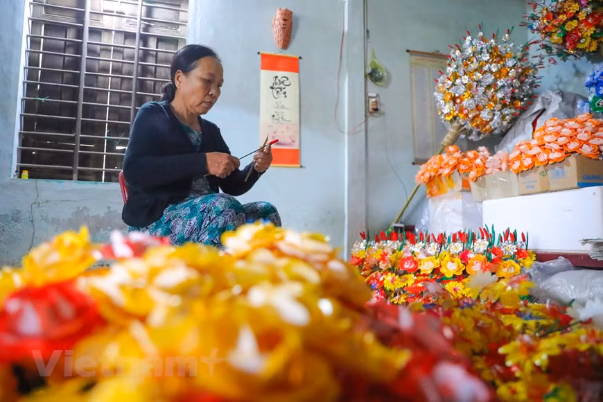 Seuls 10 ménages du village pratiquent encore ce métier et que trois d’entre eux enseignent la fabrication des fleurs en papier. toutes les étapes de fabrication des fleurs en papier se font manuellement. Tout d’abord, les villageois doivent soigneusement sélectionner le bambou, le sécher, le hacher, puis le trancher afin de fabriquer les pédicules et les tiges des fleurs. Ensuite, ils teignent le papier pour fabriquer les pétales, en utilisant des couleurs naturelles extraites des plantes locales et sans aucun produit chimique. Les fleurs sont fixées dans une botte de paille et seront ensuite transportées par les vendeurs ambulants aux quatre coins de Huê. Photo : VietnamPlus
