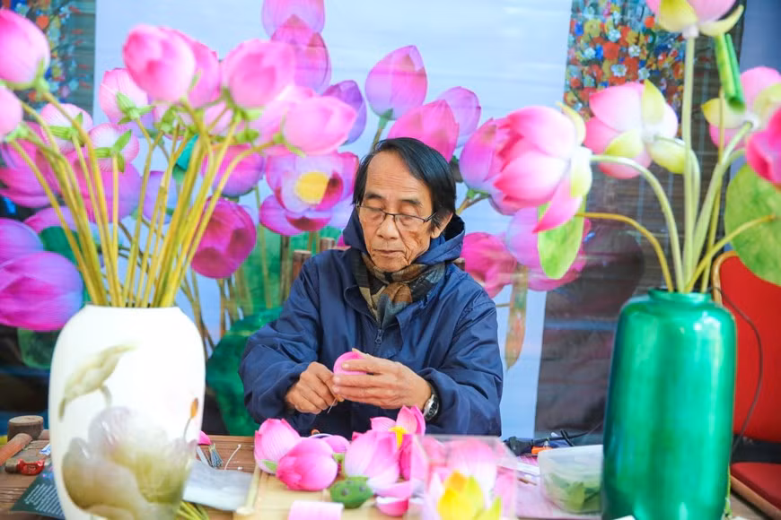 Le village de métier traditionnel de Thanh Tiên possède maintenant de nombreux artisans habiles, dont Thân Van Huy, Thân Dinh Hoai et Nguyên Hoa. Les lotus stylisés du village de Thanh Tiên, ville de Huê, sont devenus des objets symboliques de toutes les festivités organisées dans l’ancienne capitale du Vietnam.L’artisan Thân Van Huy a façonné à lui seul 150 lotus. Une réussite formidable, quand on sait que ce métier artisanal - la fabrication de fleurs en papier - avait été abandonné durant 50 ans. "Nos fleurs de lotus artificielles, en papier, figurent à chaque Festival de Huê. Elles servent d’accessoires pour les danses traditionnelles", vante le peintre Thân Van Huy. Photo : VietnamPlus