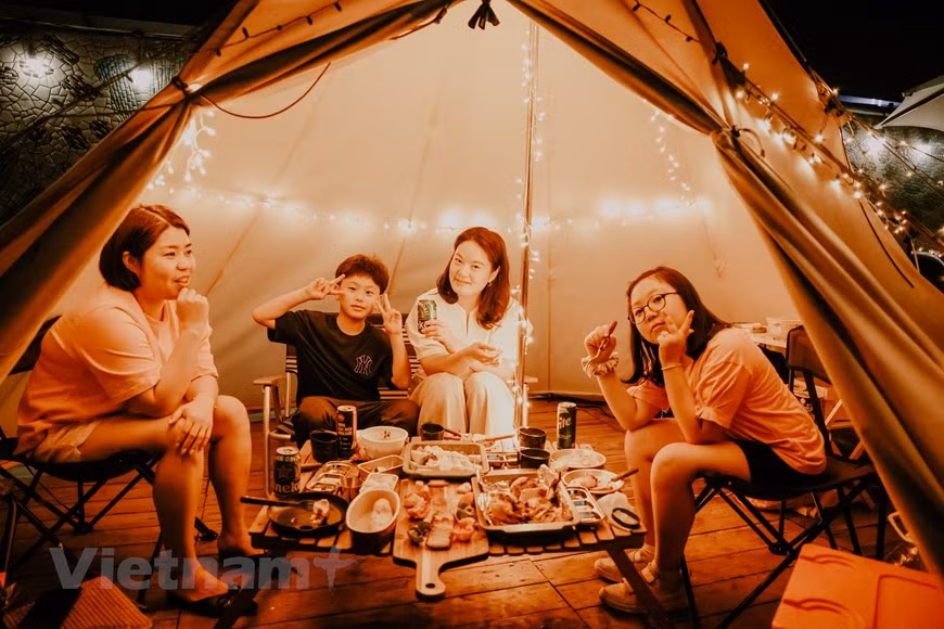 Le site de glamping se compose de trois tentes, chacune pouvant accueillir de quatre à 12 personnes. Ouvert de 18h à 23h tous les jours et le dimanche midi, il propose différents services, de la nourriture et des boissons à la musique. Des fours et autres ustensiles de cuisine sont également disponibles sur le site de glamping, permettant aux vacanciers de cuisiner eux-mêmes. Les vacanciers auront la chance de goûter des soupes à la coréenne. Sans services Internet, le glamping permet aux vacanciers de passer plus de temps avec leurs amis et leurs proches. Il offre un endroit merveilleux pour les jeunes vacanciers. Photo: Vietnamplus