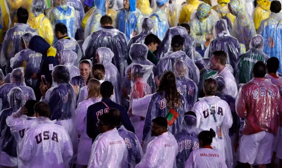 Les sportifs américains défilent avec leurs imperméables. Photo: AP