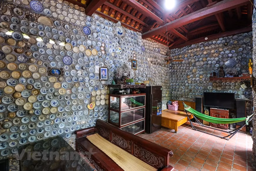 Dans le salon de la maison, les murs et des piliers sont tous couverts de porcelaines, de pièces de monnaie et de gros boutons de chemise.