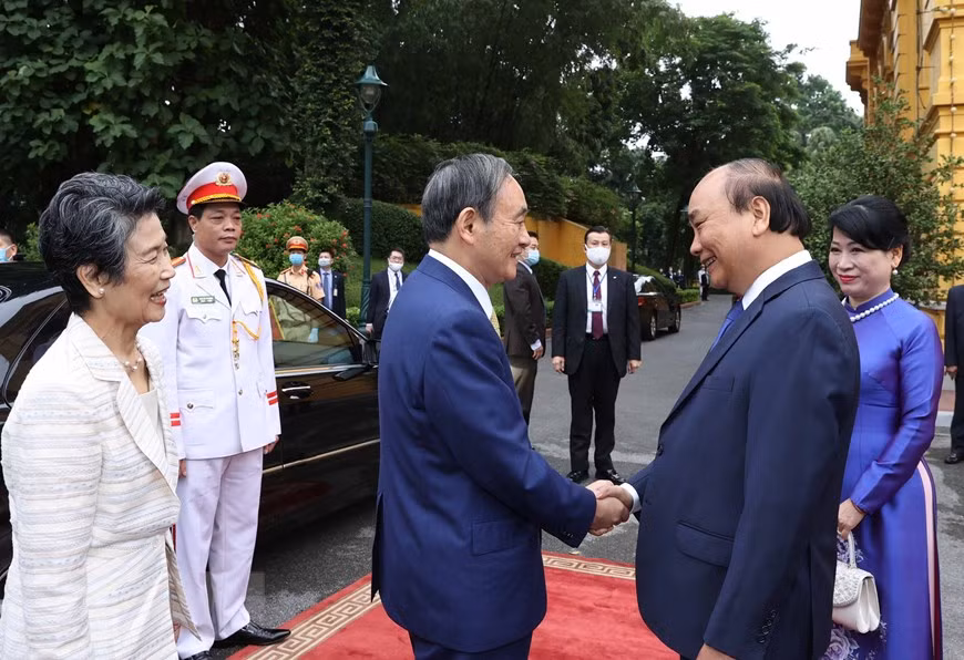  Le Premier ministre Nguyen Xuan Phuc (droite) et son épouse à la cérémonie d’accueil en l'honneur du Premier ministre japonais Suga Yoshihide et de son épouse. 