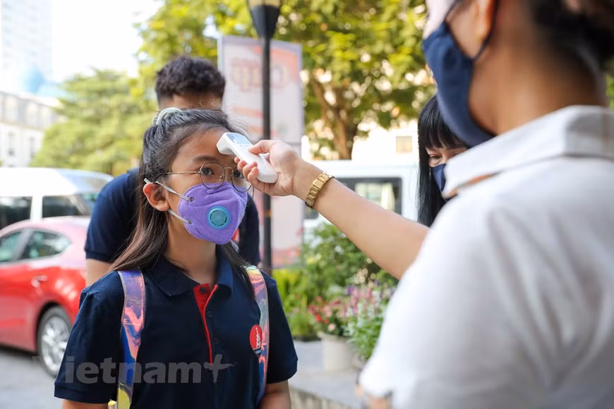  Après deux mois de vacances, avec près de 23 millions d’élèves dans l’ensemble du pays, plus de 2,1 millions d’élèves de Hanoï ont entamé le matin du 5 septembre une nouvelle année scolaire 2020-2021. À l’école Marie Curie Hanoi, tous les élèves doivent respecter les règles sanitaires pour prévenir l’épidémie du COVID-19. Élèves, enseignants et invités étaient tenus de porter un masque et d’utiliser du gel hydroalcoolique après contrôle de leur température. Les établissements d'enseignement préscolaire ont organisé leur cérémonie d'ouverture guidés par la devise ''Les enfants vont à l’école avec enthousiaste'' de manière créative, tout en respectant les principes de distanciation sociale. Photo : Vietnamplus 