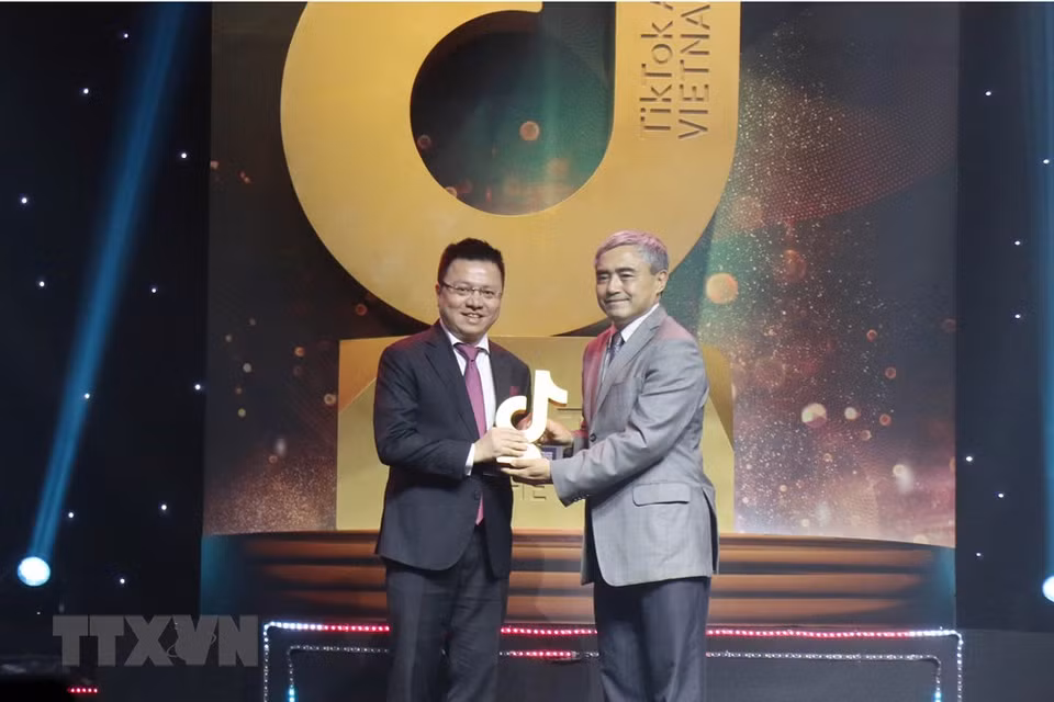  Le vice-directeur général de l’Agence vietnamienne d’Information (VNA) Le Quoc Minh (à gauche) reçoit le prix ''Community media channel of the year'' (Chaîne de médias communautaire de l’année), lors de la cérémonie de remise des Prix TikTok du Vietnam 2020, le 27 décembre à Ho Chi Minh-Ville. 