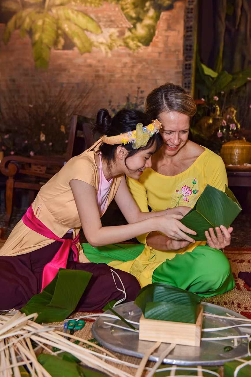 La confection du fameux « Banh chung » intéresse les amis internationaux. Photo : VNA