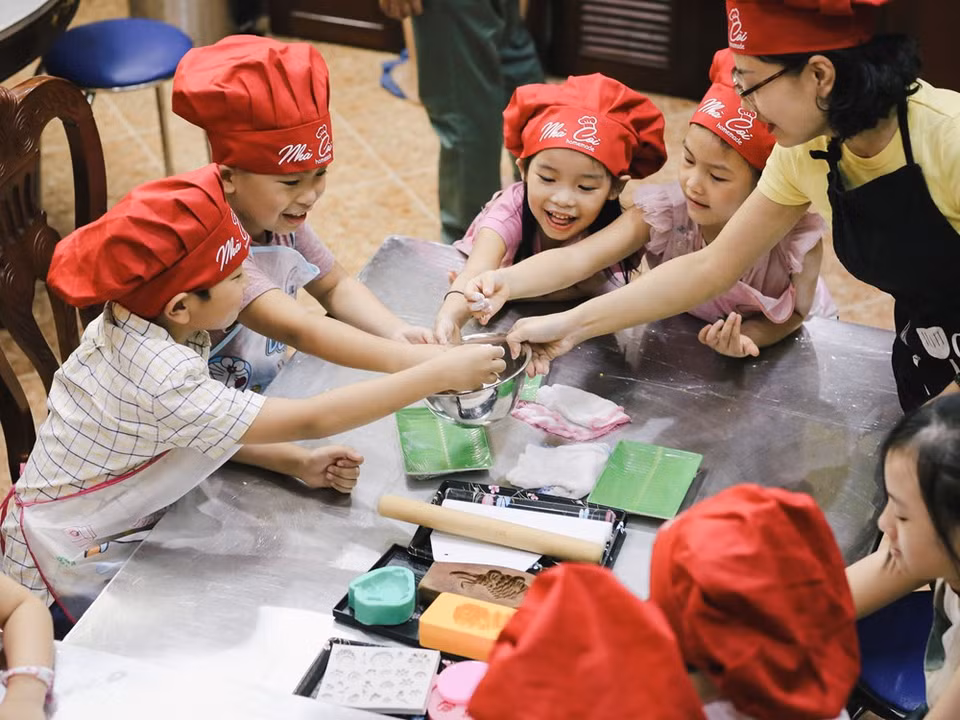 Les parents emmènent leurs enfants aux ateliers de fabrication de gâteaux de lune pour les sensibiliser à la signification de ces plats spéciaux et de la Fête de la Mi-automne.