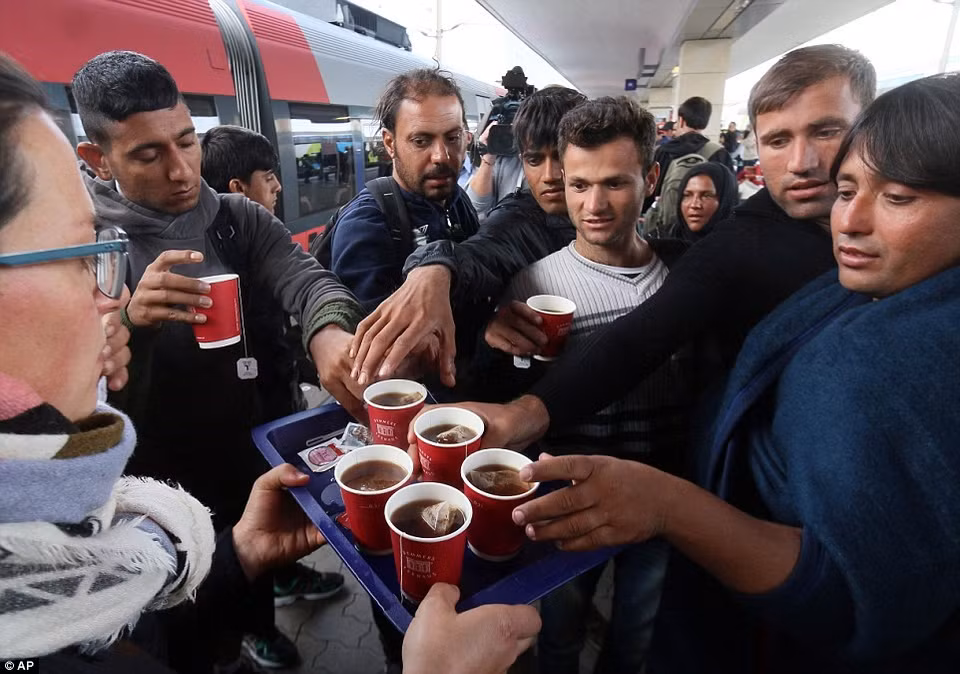 Des réfugiés prennent des tasses de thé à la Gare de l'Ouest de Vienne. 