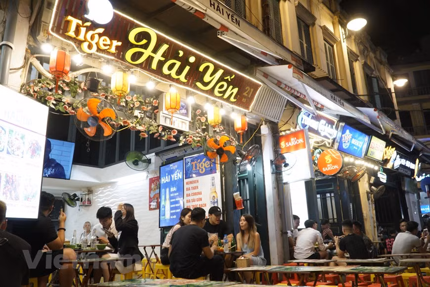 Tandis que la rue piétonnière Bùi Viên à Hô Chi Minh-Ville, surnommée "rue des Occidentaux", est réputée pour l’agitation, dans la rue Ta Hiên, se retrouvent chaque soir des jeunesses cosmopolites désireuses de découvrir le mode de vie local, mais aussi des Vietnamiens venus passer une bonne soirée entre amis. Il semble que le désaccord linguistique n’est qu’une mince affaire, tout le monde rit joyeusement. Un simple, discret, non-somptueux magasins de bière qui peuvent occuper une place particulière dans le cœur des invités ici. Ta Hiên - Ma Mây - Luong Ngoc Quyên est le "carrefour cosmopolite" avec de nombreux types de services, de lieux de restauration et de divertissements. Photo : VietnamPlus 