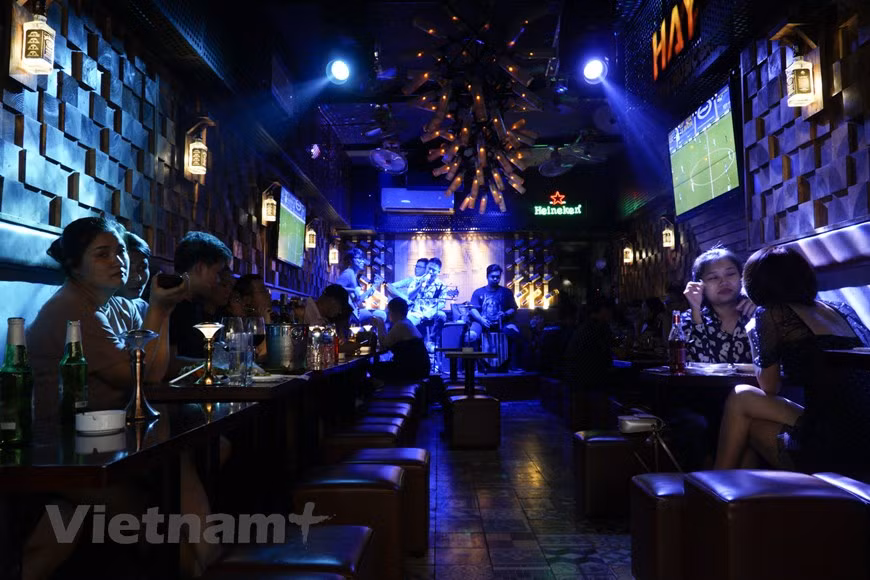  Les jeunes sont dans un bar dans la rue Ta Hiên la nuit. Ils prennent souvent de la bière, du café et d’autres boissons. En venant à Ta Hiên, on ne peut absolument pas laisser tomber les bars, les pubs animés comme: 1900 bar, Hay bar ... Avec son espace moderne, son son vivant et ses performances extrêmes, cet endroit est devenu une destination idéale pour les jeunes à vivre avec de la musique. C'est également l'un des lieux de divertissement les plus intéressants de cette rue. Tout le monde se contente de s’assoir dans une telle ambiance et écoute la musique. Photo : VietnamPlus 