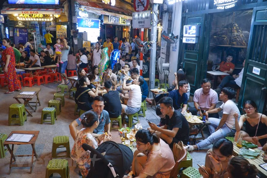 La rue Ta Hiên, qui ne dort jamais, est habituellement l’un des lieux prisés de la capitale. Cette rue accueille chaque jour un grand nombre des habitants. Depuis de nombreuses années, les Hanoïens et les touristes aiment aller à la rue Ta Hiên car ils y trouvent une ambiance agréable, des cuisines de très bon marché. Ses stands de bière pression sur le trottoir proposent toutes sortes de plats tels que cailles et calmars grillés, nem chua (hachis de porc fermenté et couenne), frites, phở xào bò (nouilles de riz à la viande de bœuf sautées)..., mais la bière reste toujours la boisson la plus choisie. Tout le monde se retrouve coude-à-coude dans une joyeuse ambiance potache. Photo : VietnamPlus 