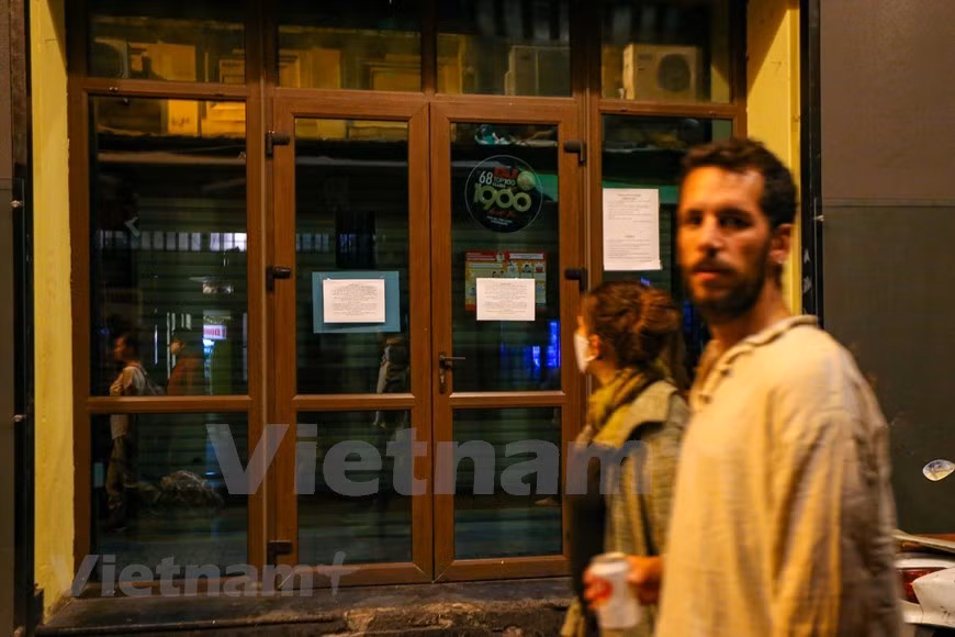  Sur les portes d'un bar sont affichés des petits mots adressés aux clientèles. Ta Hiên attire plus de touristes étrangers que n’importe quelle autre rue du Vieux quartier. Selon les Hanoiens, Ta Hiên ressemble à une jeune fille à la beauté intérieure. Pas vraiment très belle, mais beaucoup de charme, surtout le soir venu... Parfois, les étrangers y sont plus nombreux que les autochtones. Beaucoup se posent au bien nommé «carrefour international» de Luong Ngoc Quyên - Ta Hiên pour siroter de la bia hoi (bière pression populaire), fraîche et bon marché. D’autres dégustent des «plats de rue» comme nem chua (viande de porc fermentée et couenne), ôc luôc (coquillages cuits à l’eau). Photo: VietnamPlus 
