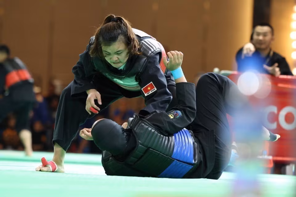 L'athlète Quang Thi Thu Nghia (ceinture rouge, gauche) a battu l'athlète Nia Larasati (Indonésie, ceinture bleue) dans la finale d'haltérophilie des 65-70 kg pour remporter la troisième médaille d'or de l'équipe vietnamienne pencak silat. 