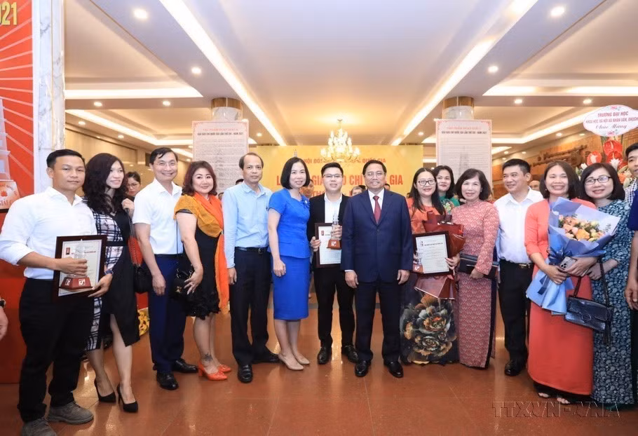 Le Premier ministre Pham Minh Chinh, la directrice générale de la VNA et les auteurs et groupes d'auteurs de la VNA lauréats du 16e Prix national de la presse - 2021. 