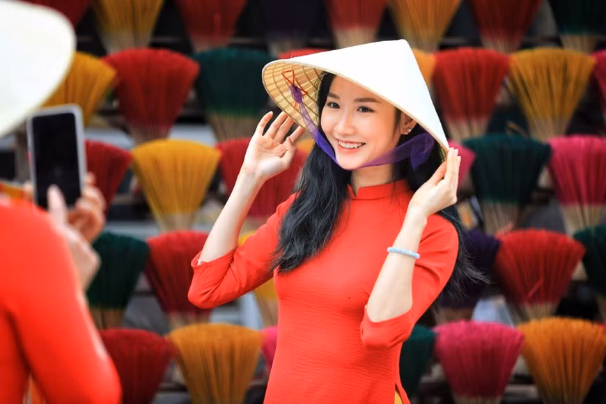 Les touristes prennent des photos devant les les bâtonnet d’encens multicolores. Photo: VNA