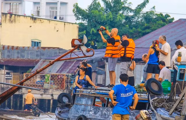 Le marché flottant de Cai B​e à Ti​en Giang est l’un des plus anciens marchés flottants de cette région. En plus de la scène trépidante des jonques et des bateaux, ce marché attire les visiteurs par l'image qu'il renvoie d’un centre urbain tranquille, avec des ​vergers qui se suivent, des rangs de rues anciennes tout au long du bassin de la rivière, qui tantôt apparaissent tantôt disparaissent sous les rangs des cocotiers aquatiques.