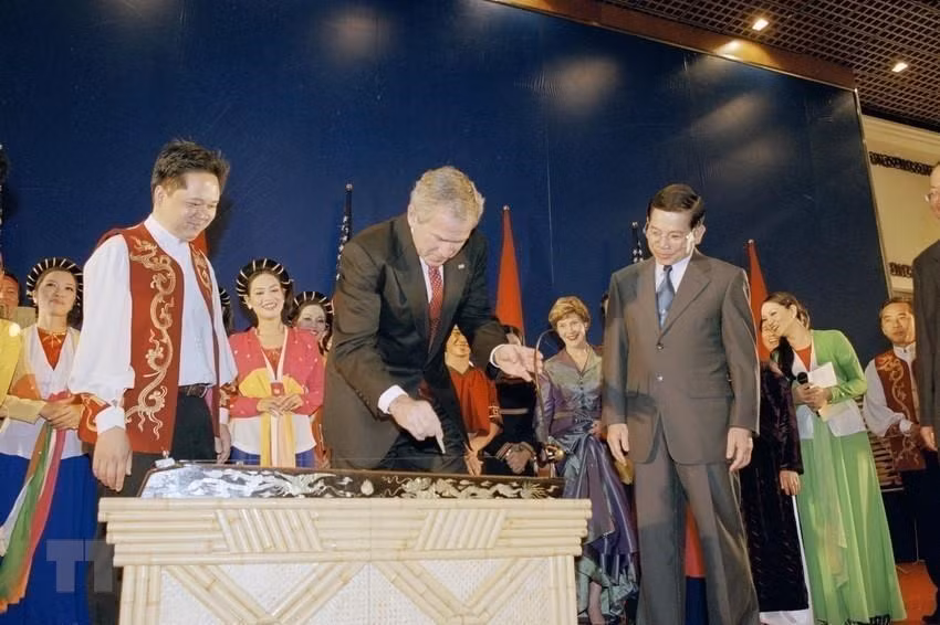 Le président américain George W. Bush joue le "dan bau", un instrument de musique traditionnelle du Vietnam lors d'un banquet donné par le président Nguyen Minh Triet, à l'occasion de sa visite officielle au Vietnam du 17 au 20 novembre 2006. Photo: Nguyen Khang/VNA 