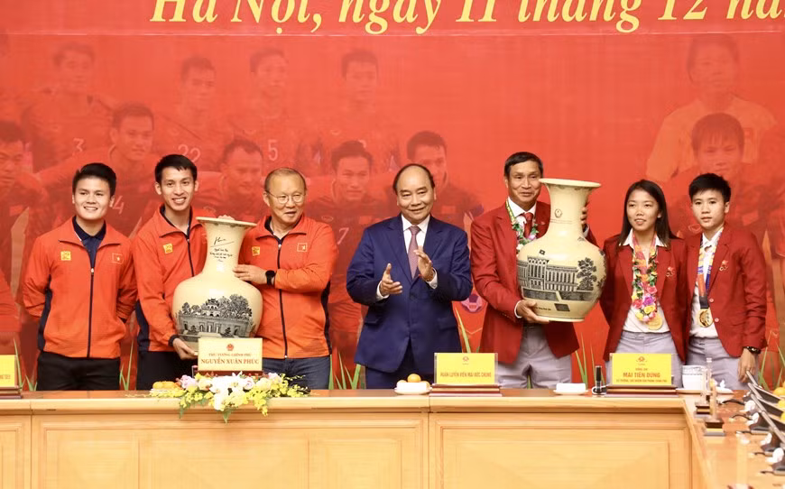 Le Premier ministre Nguyen Xuan Phuc offre deux vases en céramique aux équipes masculine et féminine. 