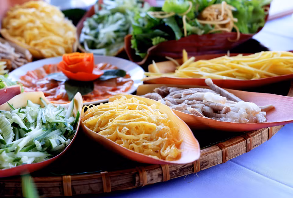 Les œufs frits, le concombre, le bacon, la mangue coupée en tranches… sont disposées sur des pétales de fleur de bananier et sont cuits ensemble dans la fondue Tha. Photo : VNA 