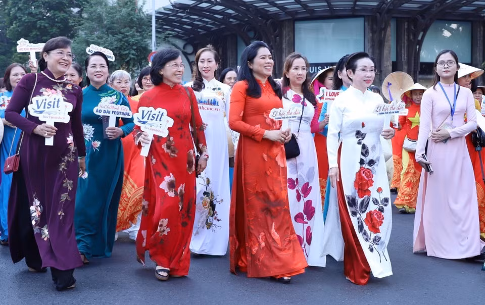  Des femmes en ao dai, tunique traditionnelle des femmes vietnamiennes, dans une rue de Ho Chi Minh-Ville. Photo: VNA 