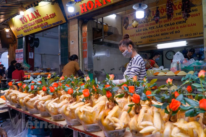 L’un des spécialités du marché Hang Be est le coq de culte. En effet, parmi les offrandes de culte préparées lors des fêtes (familiales ou communautaires), outre un plateau de xôi (riz gluant cuit à vapeur), le poulet bouilli à l’eau est un élément le plus important. Il est agréable de voir sur le plateau rituel un joli coq doré et de belle prestance. Cet «oiseau sacré» peut se présenter dans des positions différentes, appelées par exemple «Coq en vol» (gà bay), «Coq en prosternation» (gà quy), «Coq en audience royale» (gà châu), «Coq aux ailes de fée» (gà canh tiên)… Il existe même un art de la cuisine dédié exclusivement à la préparation et à la présentation du coq de culte. Photo: Vietnamplus