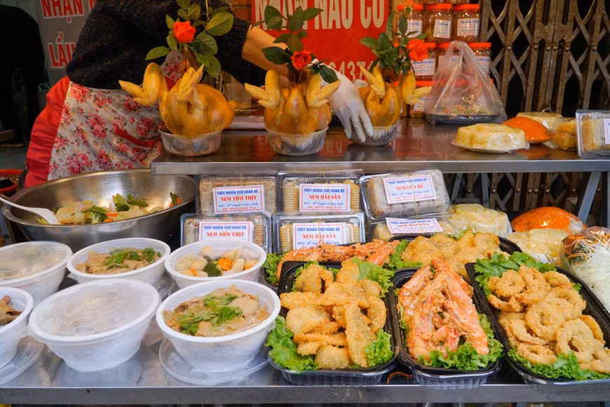 Outre le coq de culte, on peut acheter d’autres plats tels que xoi gac (riz gluant mélangé avec la pulpe de momordique et cuit à vapeur), le "nem" (rouleaux de printemps frits), canh mang (soupe aux cuisses de porc et aux pousses de bambou mijotées), bo sot tieu den (bœuf sauté en sauce au poivre noir), nom du du (salade de papaye verte), gio (pâté de viande pilée), giò thu (pâté de tête de porc) …Le Têt Nguyên Tiêu permet de se retrouver en famille. Plus les plateaux sont riches, plus cela exprime le respect envers les ancêtres. Les plateaux traditionnels se composent de nombreux mets et symbolisent tous divers souhaits et vœux de chaque famille pour la nouvelle année. Photo: Vietnamplus