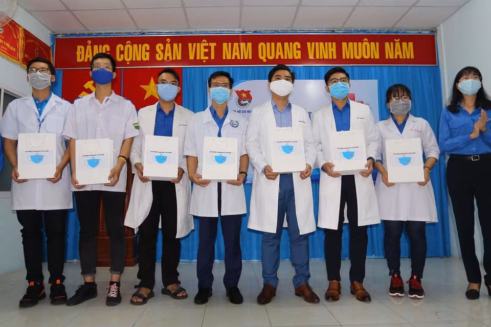 Des responsables de l'Union de la jeunesse communiste Hô Chi Minh dans la mégapole du Sud offrent du matériel médical à des membres d'une équipe de jeunes volontaires pour soutenir la prévention et le contrôle de l'épidémie de COVID-19 (2020). Photo : VNA