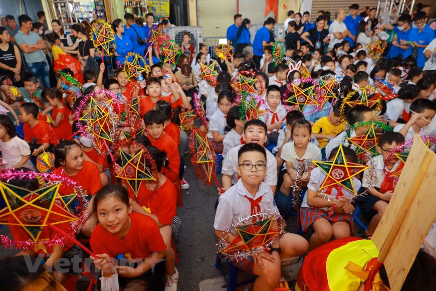 Des enfants attendent avec impatience l’atmosphère chaleureuse de la Fête de la Mi-automne. Aux yeux des enfants vietnamiens, la nuit de la pleine lune du 8e mois lunaire est une nuit miraculeuse. C'est pour eux l'occasion de recevoir des cadeaux, qui sont généralement des jouets traditionnels comme les lampions ("lồng đèn giấy), les lanternes en forme d'étoile ("đèn ông sao"), les docteurs en papier ("tiến sĩ giấy"), les masques en carton ("mặt nạ giấy"),… Parmi les jouets traditionnels destinés à la Fête de la Mi-automne, les lanternes en forme d'étoile sont peut-être le jouet le plus populaire. Les lanternes sont faites de bambou, de papier cellophane et de troncs de jute. Photo: VietnamPlus