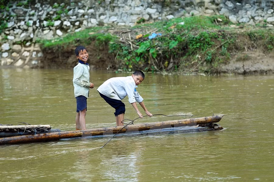 Une trentaine de foyers vivant dans le hameau de Pom Sinh, commune de Chiêng Dông, district de Tuân Giao, province montagneuse de Diên Biên (Nord-Ouest), doivent risquer leur vie pour traverser la rivière en radeau de bambou. Photo: VNA