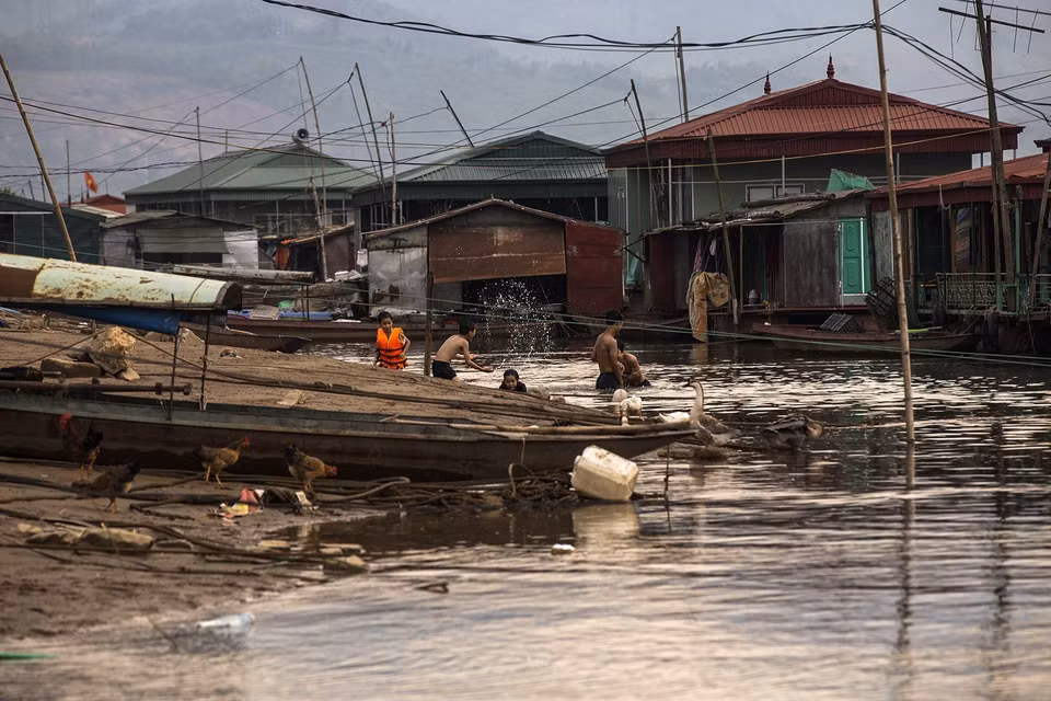 Des enfants du village de pêcheurs s'amusent dans la rivière Da. Photo: VNA