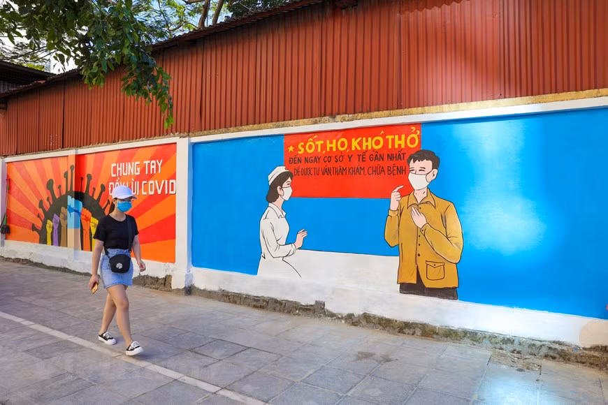 Les belles paroles de ces dix peintures murales constituent non seulement une gratitude envers les forces engagées dans la lutte contre l’épidémie de Covid-19, mais encore des louanges à l'esprit d'unité nationale - un esprit très «vietnamien» -, comme "la volonté du Vietnam peut a un pouvoir magique", "toute la nation est unie quand la Patrie et l’Etat appellent son nom", "il y a des grands sacrifices silencieux contre le combat du Covid-19 sans balles", "notre pays est petit, mais très fiers des deux mots "Viêt Nam"", "un esprit vietnamien, une solidarité fait la force»… Tout pense que le Vietnam devra vaincre cette épidémie. Photo : VietnamPlus