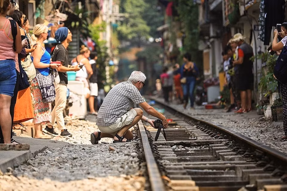 Un étranger installe son appareil photo pour capturer des images de l’arrivée du train