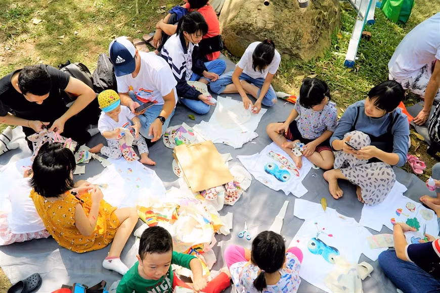 L'événement propose plus de 30 activités créatives en plein air pour les enfants et leurs familles, telles que des projets de recyclage des restes de tissu, de collecte de bouteilles en plastique, des activités artistiques,... Photo: Vietnam+