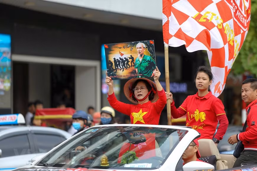 Des mordus du ballon rond portent des chemises rouges avec une étoile jaune. Photo: Vietnam+