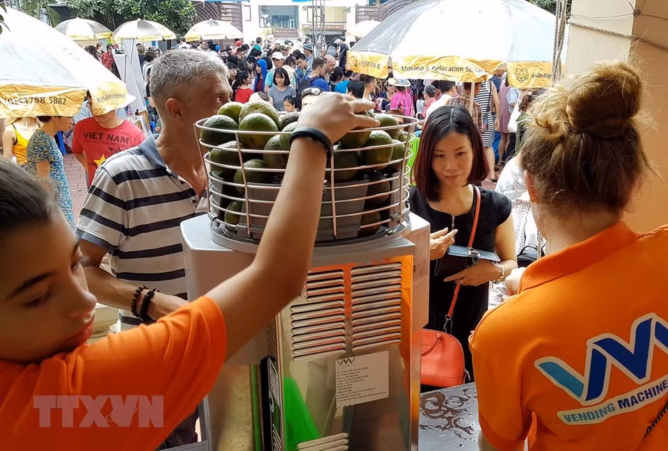  La machine à jus d'orange fonctionne à pleine capacité pour servir des clients. 