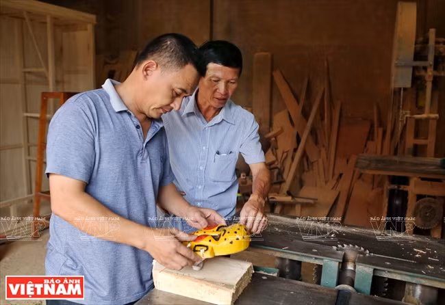  L’artiste Hung et un menuisier sculptent des masques pour les danseurs. 