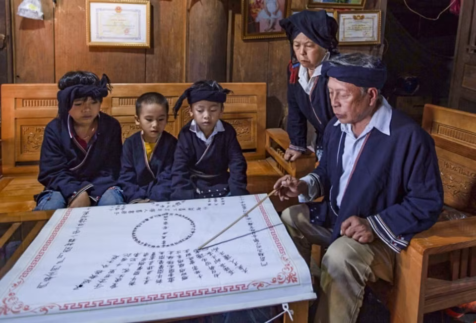 Ly Van Henh enseigne l'écriture Nom - Dao à des enfants. 