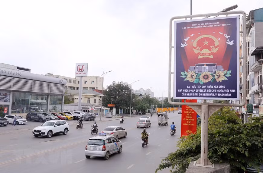  Un panneau d’affichage et des solgans le long de la rue Nghi Tam. Photo : VNA