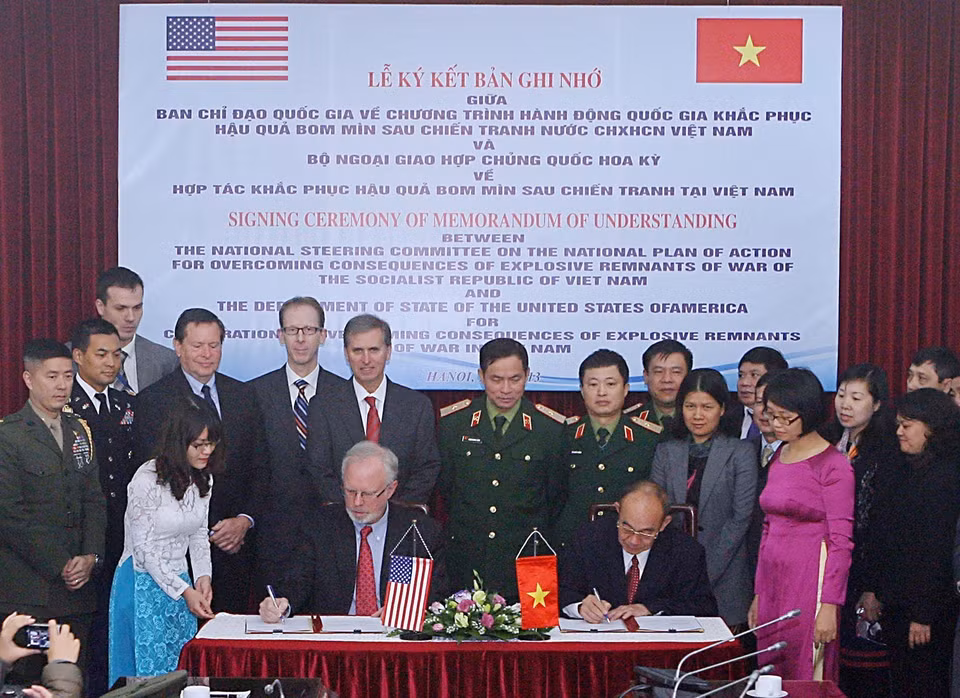 La cérémonie de signature d'un protocole d'accord entre le Comité directeur national sur le Plan d'action national pour le règlement des conséquences des bombes et mines laissées par la guerre et le Département d'État des État-Unis sur la coopération bilatérale en la matière, le 16 décembre 2013 à Hanoï.